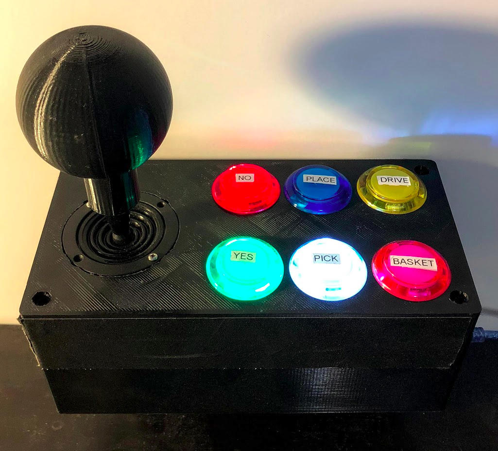 Joystick and panel of buttons used to control TUI. The buttons can light up or flash to indicate actions that the user can take.